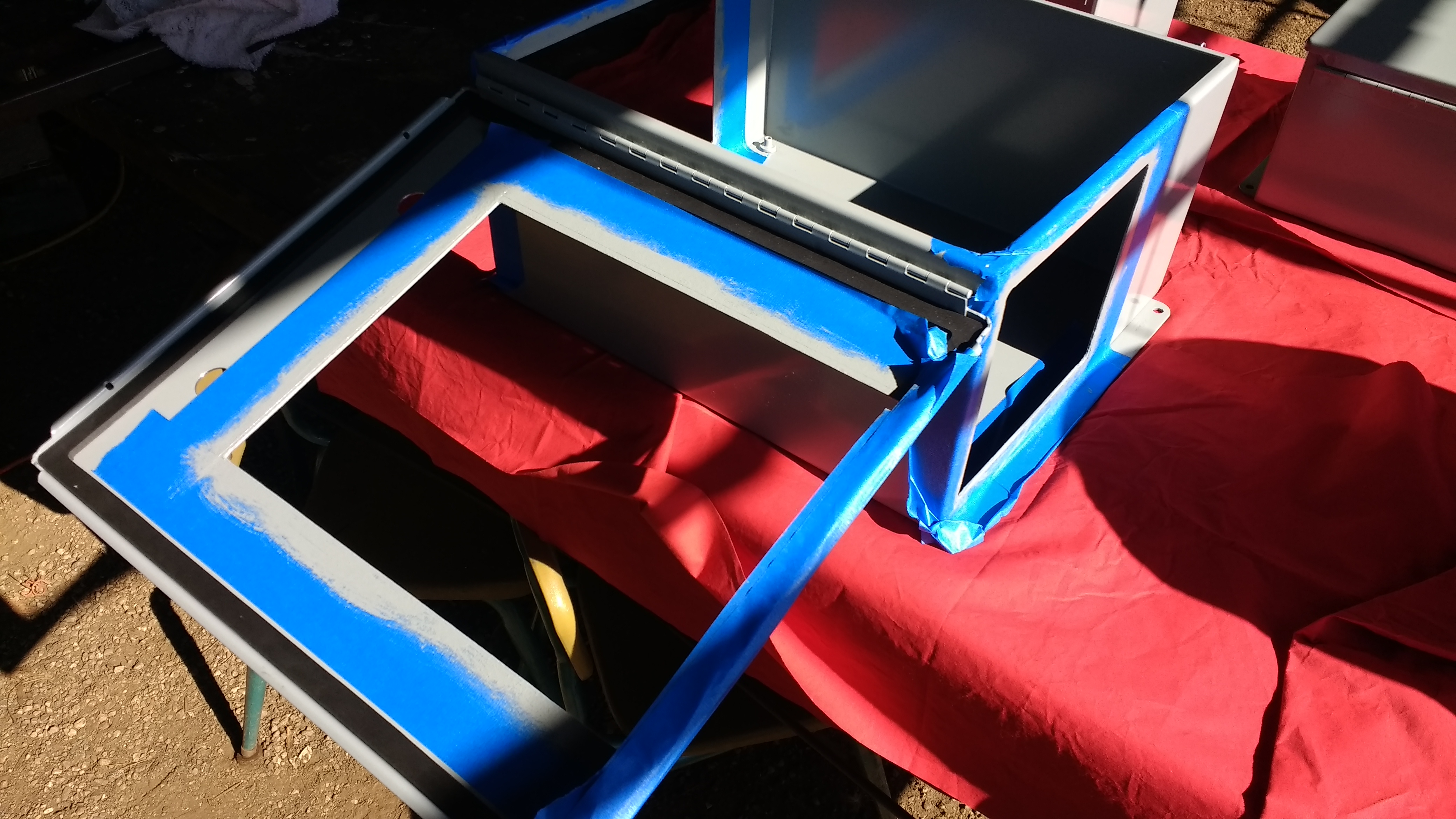 The empty enclosure covered in blue tape for painting the inside lip of the enclosure's cutouts